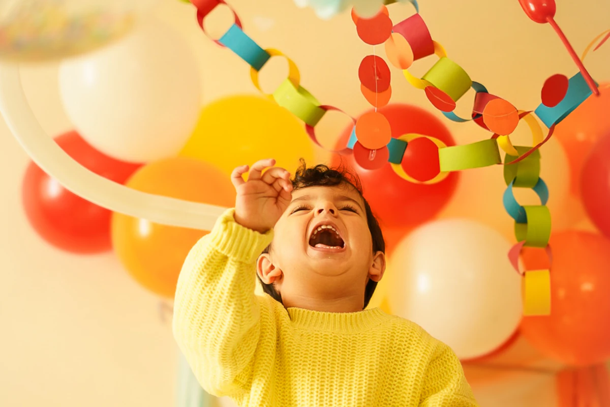 Lachend kind tussen ballonnen op een kinderfeest in de zaal