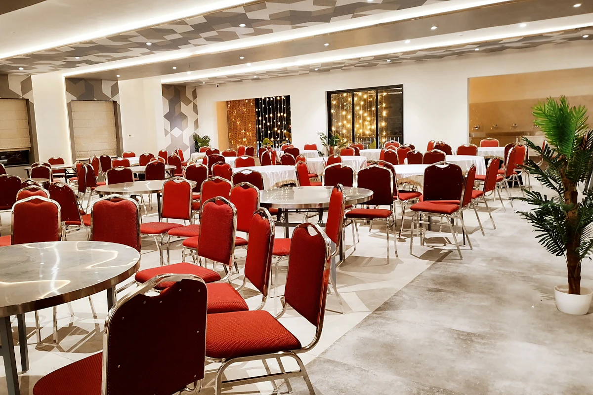Zaal in Etten-Leur met ronde tafels en stoelen, klaar voor gasten